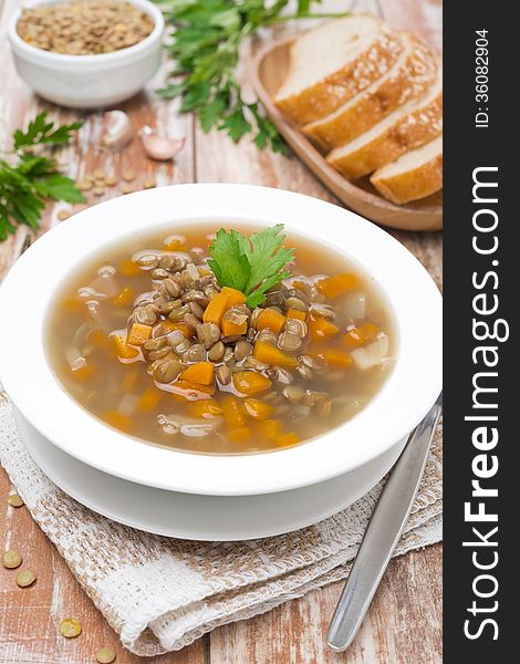 Vegetable soup with lentils on a wooden table, vertical. Vegetable soup with lentils on a wooden table, vertical