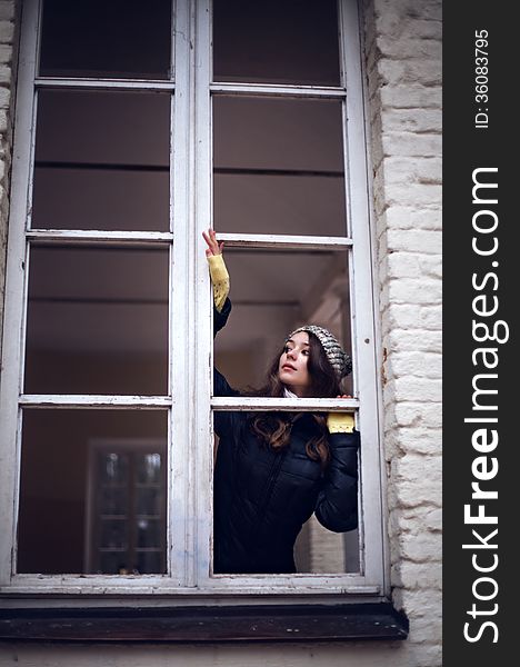 Beautiful woman looking through the window and fearing of something