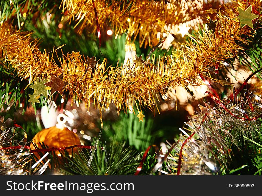 Detail of golden christmas chain on a tree branch. Detail of golden christmas chain on a tree branch
