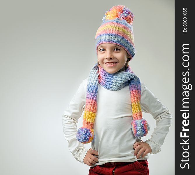 Portrait of girl in knitted hat and scarf on a light background. Portrait of girl in knitted hat and scarf on a light background