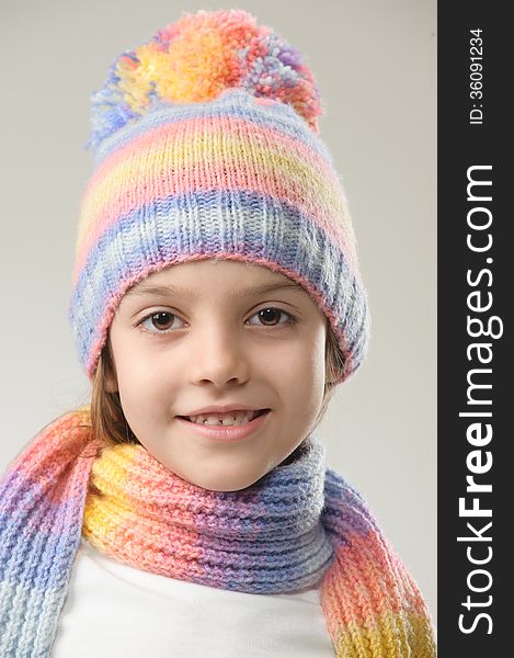 Portrait of girl in knitted hat and scarf on a light background. Portrait of girl in knitted hat and scarf on a light background