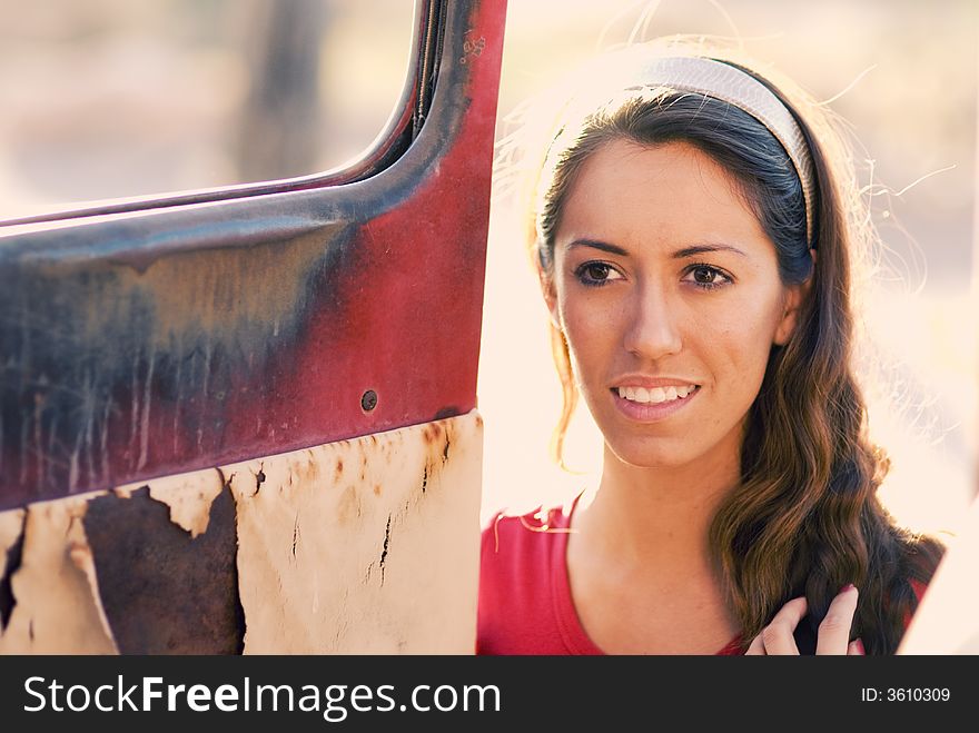 Woman beside old rusty truck door