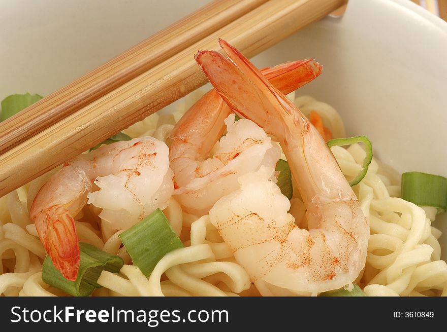 Bowl of oriental shrimp served with rice noodles.