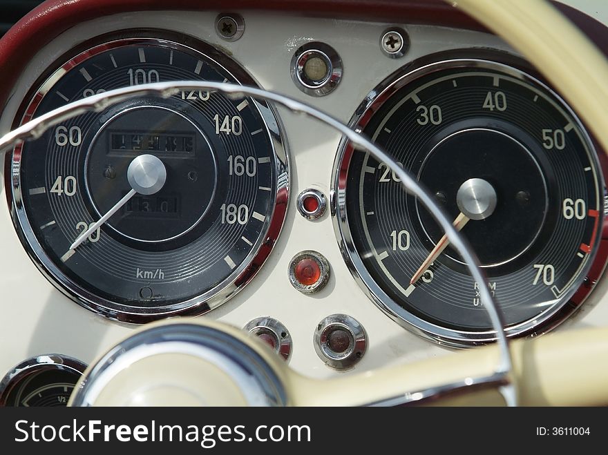 Dashboard and instrument of classic, cream coloured, German sportscar from the fifties. Dashboard and instrument of classic, cream coloured, German sportscar from the fifties.