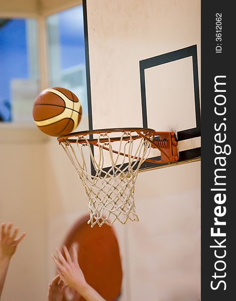 Basketball balancing on the edge of the hoop