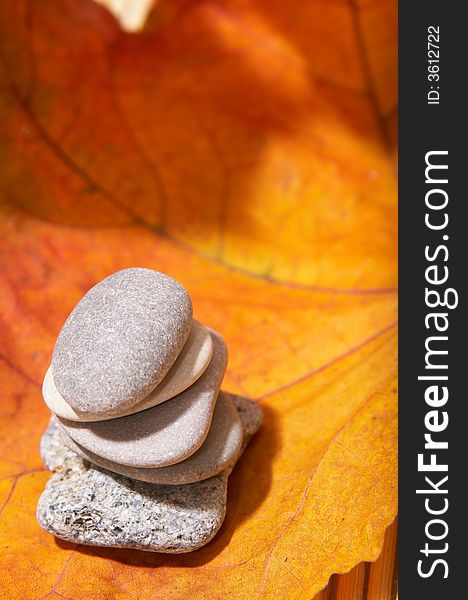 Five flat stones over autumn leaves. Five flat stones over autumn leaves