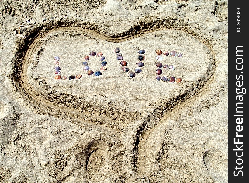 Word love written in the sand with shells. Word love written in the sand with shells