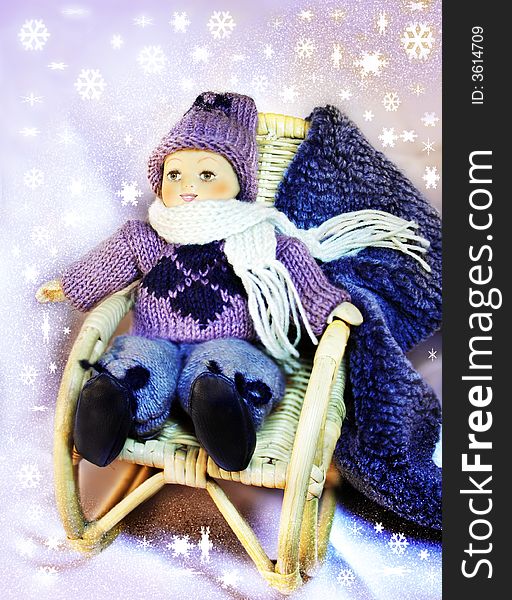 Dolly sitting on a rocking chair,snow background,sparkles stream. Dolly sitting on a rocking chair,snow background,sparkles stream