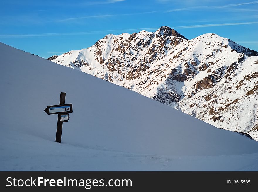 Trail direction signs in snowed mountain