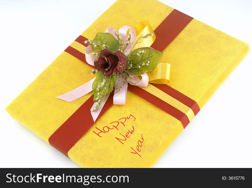 Yellow gift box with red ribbon and flower
