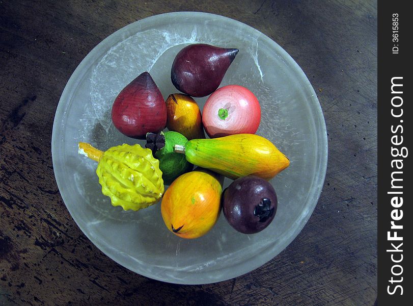 Wooden fruit in a glass plate