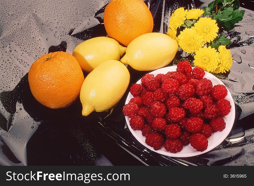Raspberry, orange, lemon, on a black background