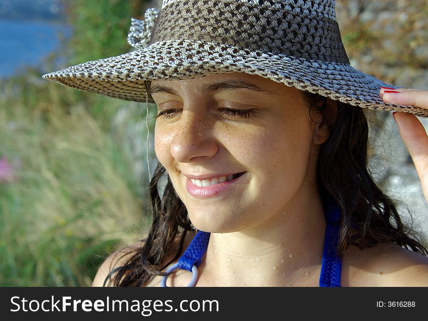 A girl wearing a hat against the hot summer sun at the beach in montenegro. A girl wearing a hat against the hot summer sun at the beach in montenegro