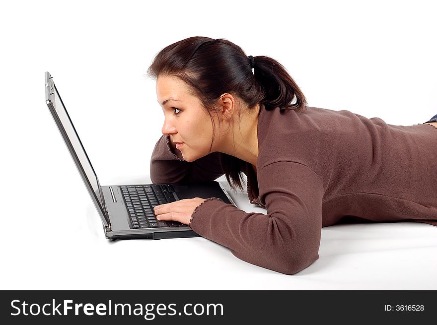 Attractive brunette woman lying with laptop on white background. Attractive brunette woman lying with laptop on white background