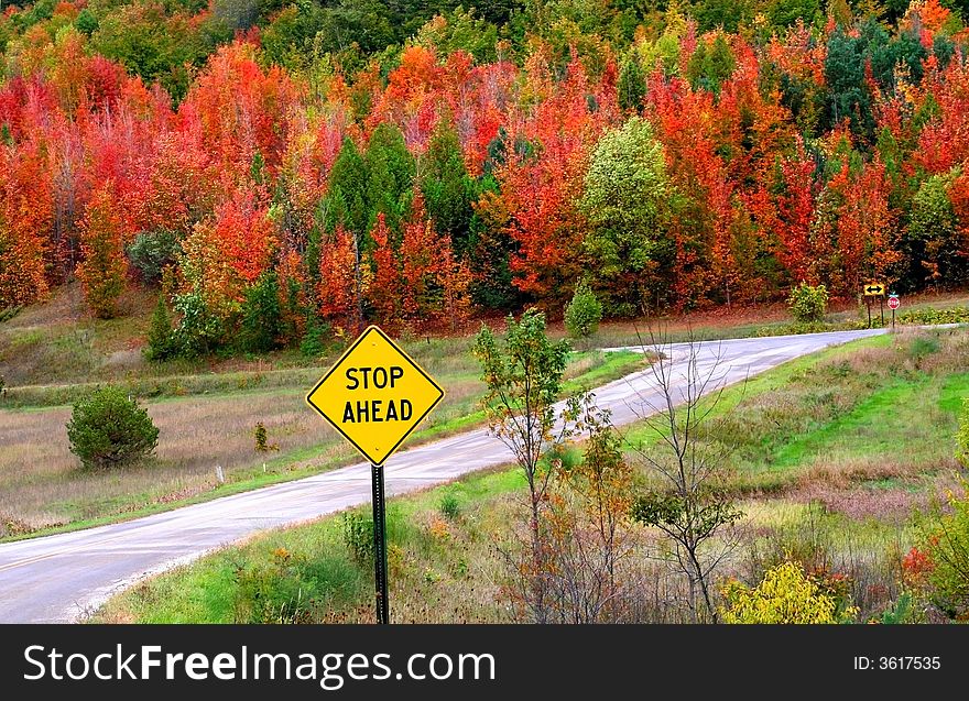 Stop ahead sign in the middle of beautiful autumn landscape