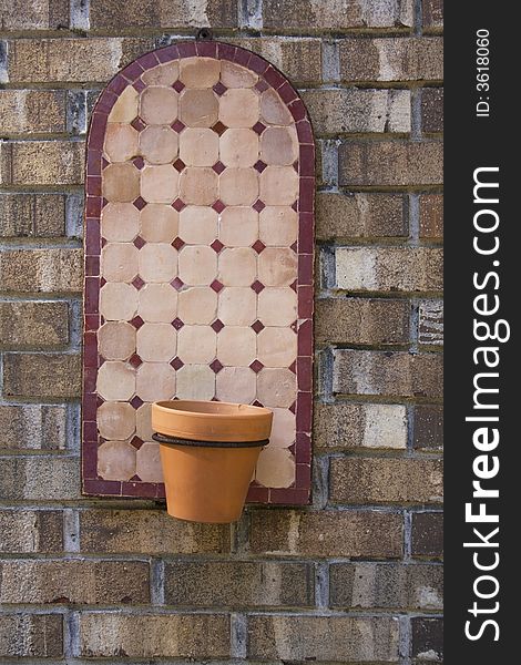 Terra Cotta pot on ceramic hanger on brick wall. Terra Cotta pot on ceramic hanger on brick wall