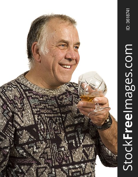 Smiling and happy older man drinking single malt scotch from a crystal glass - isolated on white. Smiling and happy older man drinking single malt scotch from a crystal glass - isolated on white