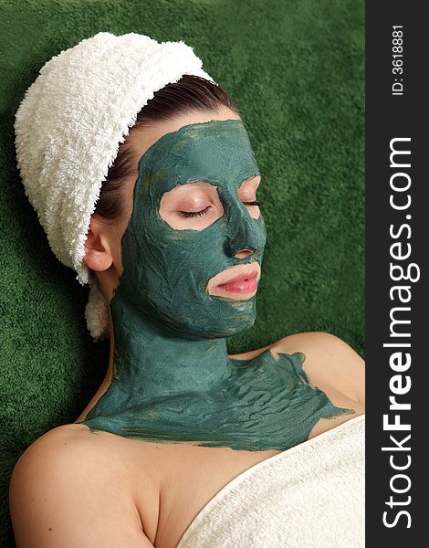 Beautyful young woman with green moisturizing facial cream. Beautyful young woman with green moisturizing facial cream