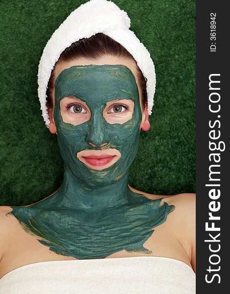 Beautyful young woman with green moisturizing facial cream. Beautyful young woman with green moisturizing facial cream