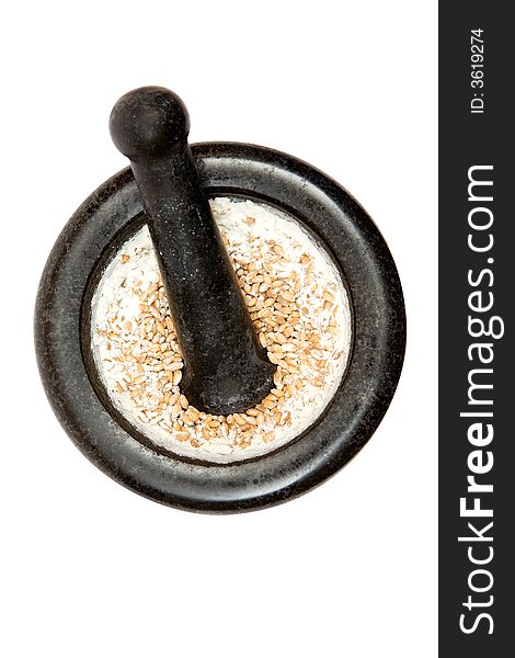 Grinding wheat in a kitchen pestle. Isolated on a white background.