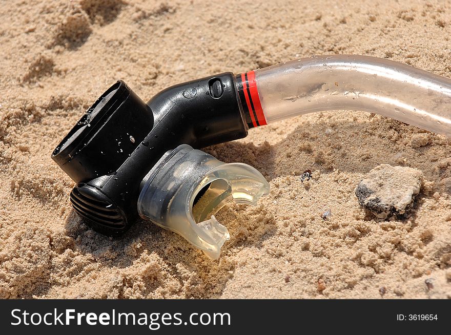 A closeup of the mouthpiece of a plastic snorkel, left on the beach. A closeup of the mouthpiece of a plastic snorkel, left on the beach.