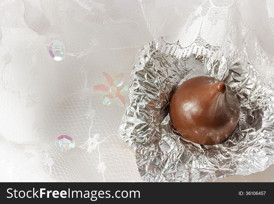 Chocolate With Foil On Lace Background.