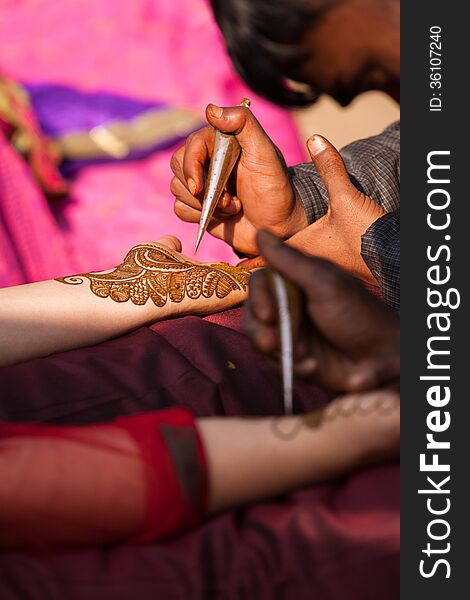 Indian bride getting henna mehndi designs on her hand for the wedding. Indian bride getting henna mehndi designs on her hand for the wedding