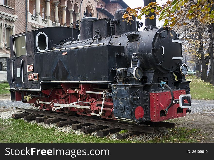 A vintage locomotive stationed in front a museum. A vintage locomotive stationed in front a museum