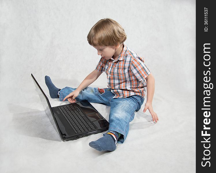 The boy turned on the laptop clicks on the keyboard. The boy turned on the laptop clicks on the keyboard