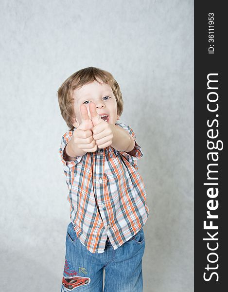 Blond boy shows both hands okay and laughs. Blond boy shows both hands okay and laughs