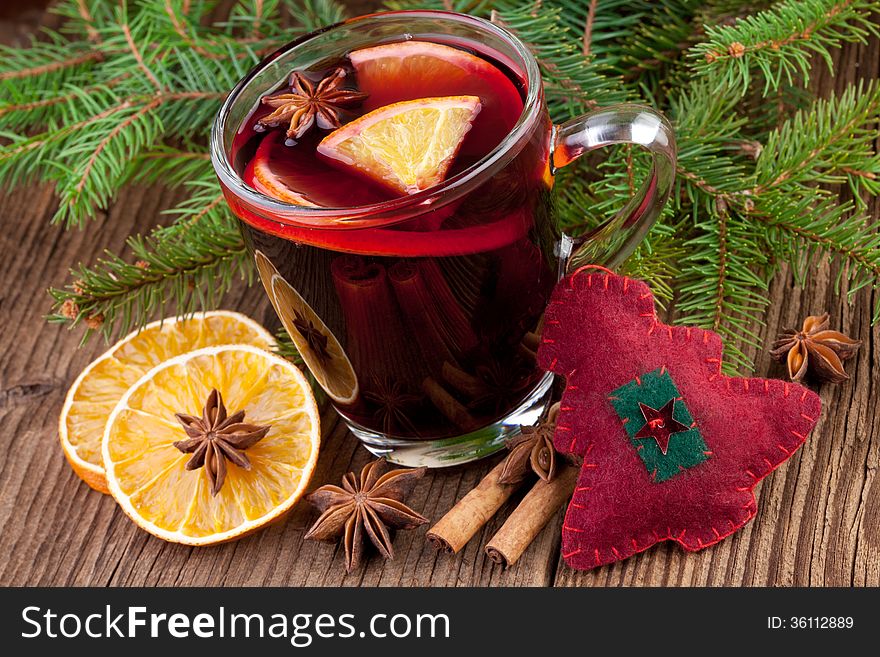 Christmas mulled wine in a glass on old wooden background