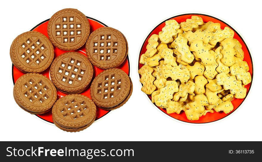 Two types of cookies on the red saucers, isolated on white background