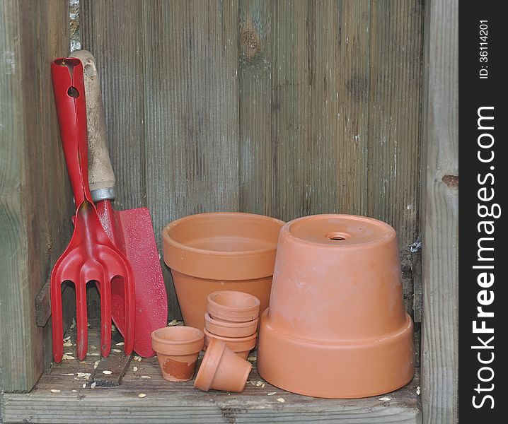 Small tools and terracotta pots in a wooden crate. Small tools and terracotta pots in a wooden crate