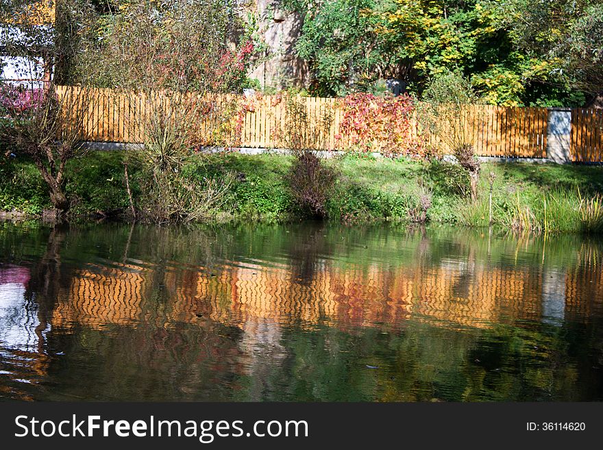 Wooden fence in garden with pond