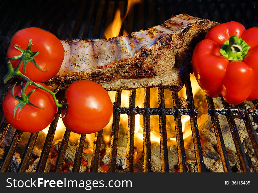Ribs roasted in a barbecue with pepper and tomatoes