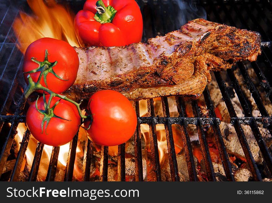 Ribs roasted in a barbecue with pepper and tomatoes. Ribs roasted in a barbecue with pepper and tomatoes