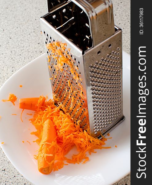 Hand grating carrots, which applies to a very healthy food. Hand grating carrots, which applies to a very healthy food.