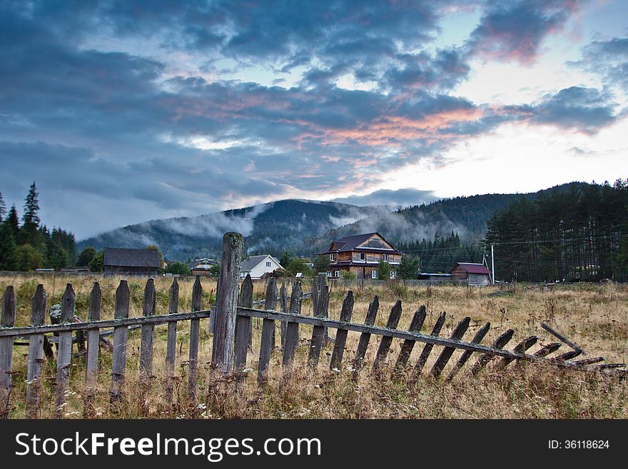 Sunset in the mountains in the village in the Carpathians. The sky in the clouds, autumn and cold