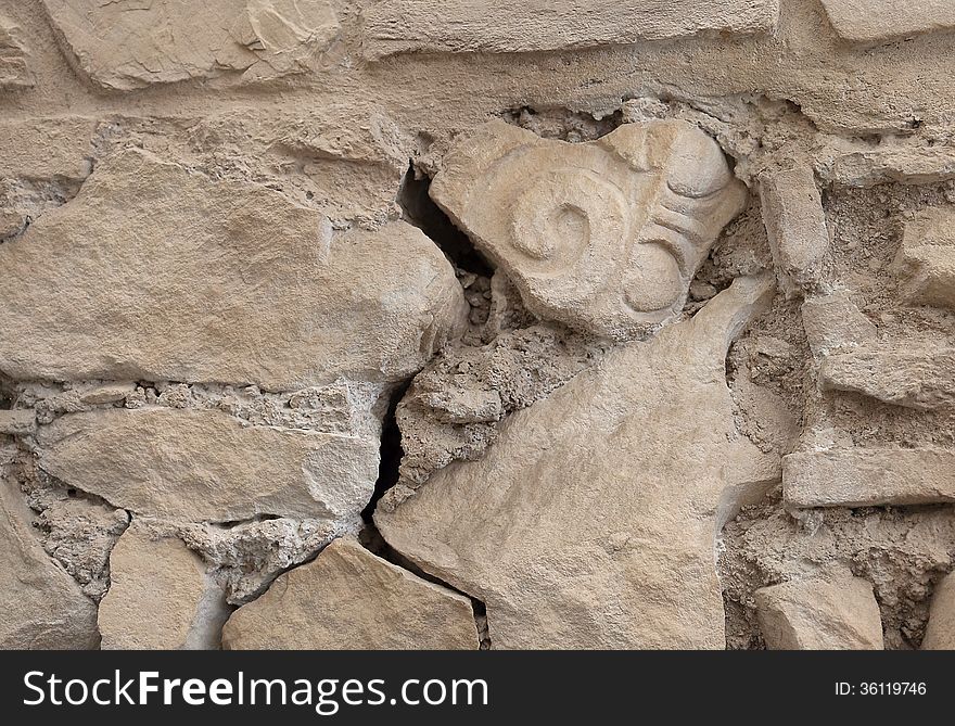 Ancient wall with an older fragment of a column in it