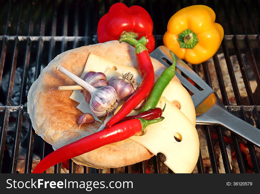 Bread, cheese, Chili Pepper and garlic on the background of coals. Bread, cheese, Chili Pepper and garlic on the background of coals