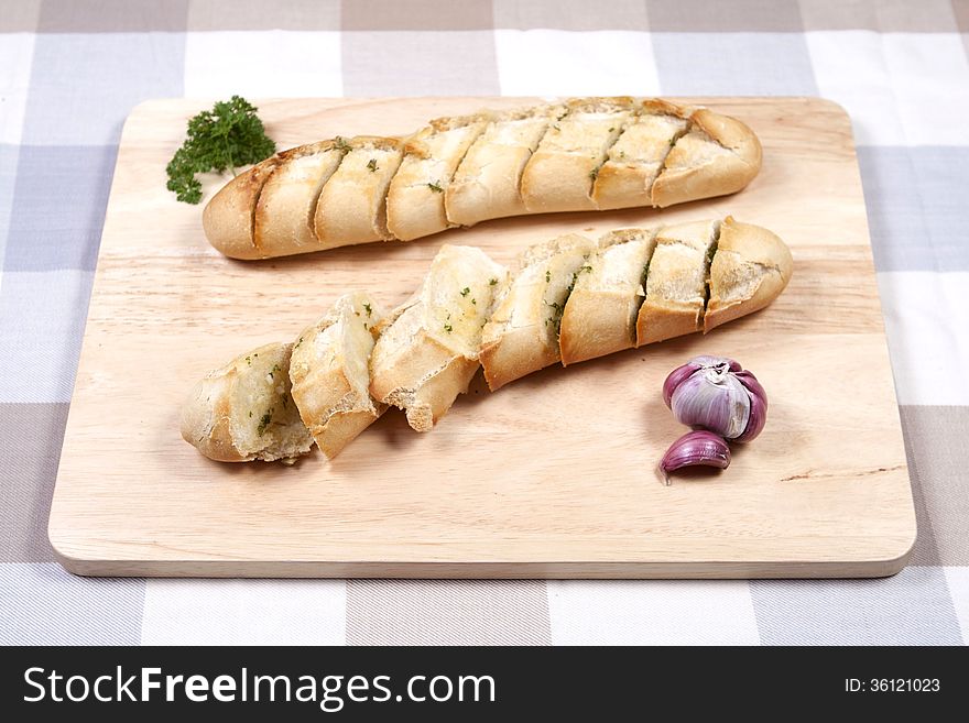 A wooden board with two garlic breads