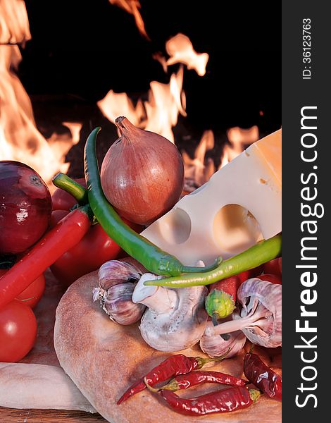 Fresh Bread and Vegetables on a Wooden Panel front of an Open fire. Fresh Bread and Vegetables on a Wooden Panel front of an Open fire