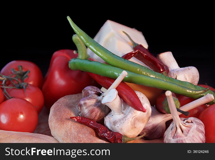 Fresh bread and vegetables on a black background