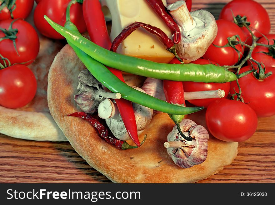 Fresh bread and vegetables on a wooden panel