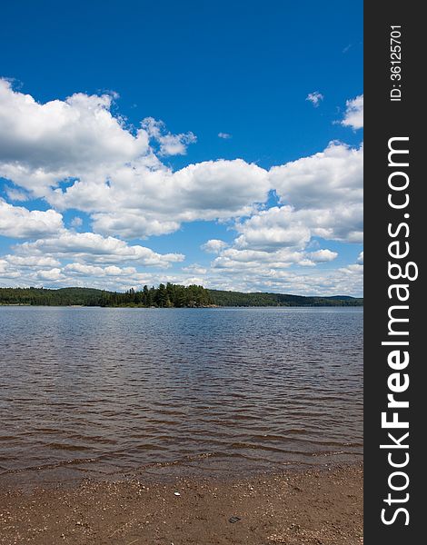 Image of a lake on a calm day against a backdrop of a forest at Algonquin Park, Ontario, Canada. Image of a lake on a calm day against a backdrop of a forest at Algonquin Park, Ontario, Canada