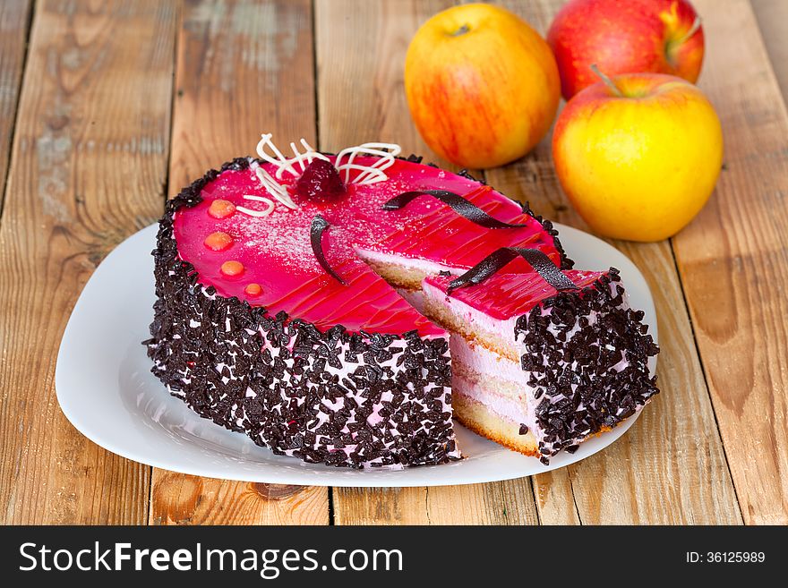 Jelly cake with whipped cream on a wooden table with apples. Jelly cake with whipped cream on a wooden table with apples