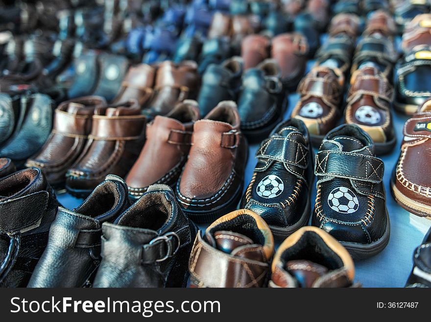 A swap meet table full of kids shoes for sale. A swap meet table full of kids shoes for sale