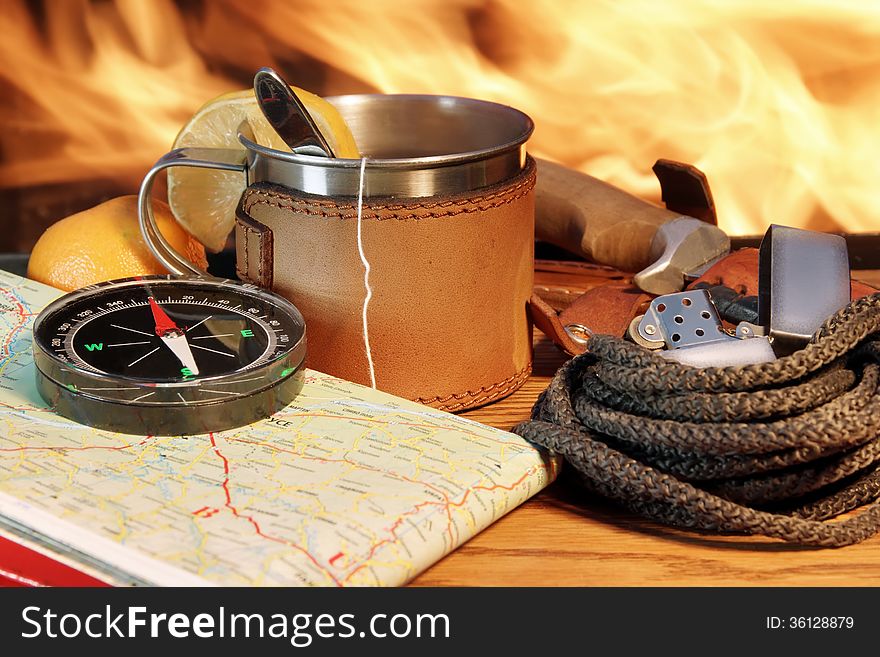 Compass, Map, Mug of Tea, Lighter and Rope on a Wooden Plank at Campfire. Compass, Map, Mug of Tea, Lighter and Rope on a Wooden Plank at Campfire