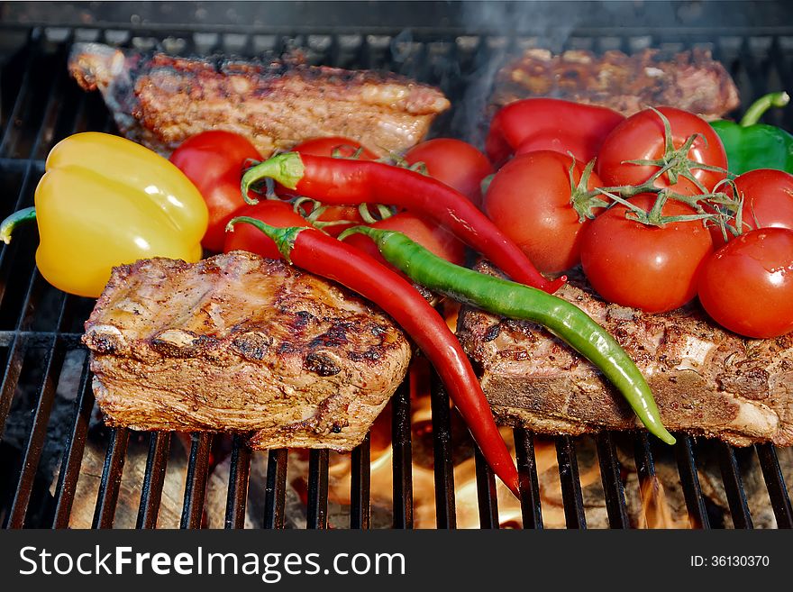 Ribs and brisket roasted in a barbecue with vegetables. Ribs and brisket roasted in a barbecue with vegetables