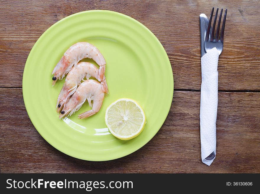 Shrimps portion on green plate with lemon slice